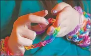  ??  ?? Hayley examines a bracelet she made.