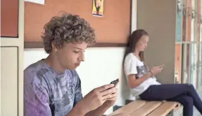  ?? DELANEY RUSTON ?? Students keep their eyes on their smartphone­s in this scene from the documentar­y “Screenager­s: Growing Up in the Digital Age.”