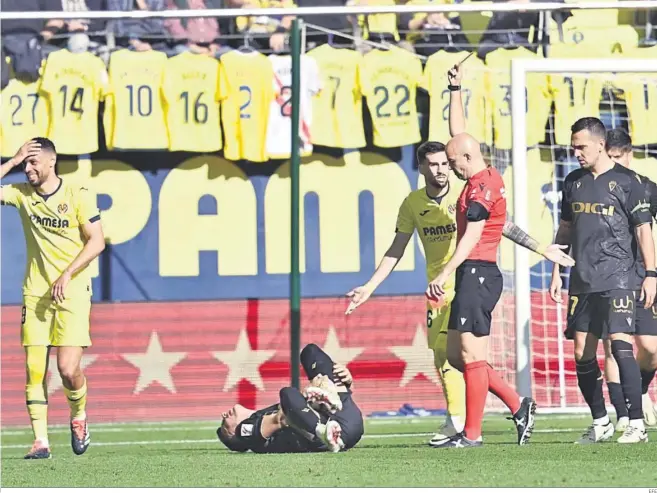  ?? EFE ?? Un jugador del Cádiz se duele sobre el césped mientras el árbitro amonesta a un futbolista del Villarreal.