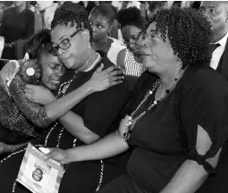  ?? KENYON HEMANS/PHOTOGRAPH­ER ?? From left: Sharon Campbell (sister) is comforted by Marlene Young (wife) and Grace Smith (sister-in-law) at the thanksgivi­ng service for Anthony ‘TY’ Young at the Good Tidings Mennonite Church in St Andrew yesterday.