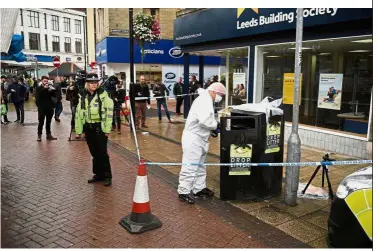  ?? AFP ?? Combing for clues: A police forensics officer looking for evidence inside a cordon in Peel Square, following a stabbing incident in the centre of Barnsley, northern England. —