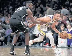  ?? AFP ?? The Warriors’ Stephen Curry, right, drives against the Nets’ Caris LeVert.