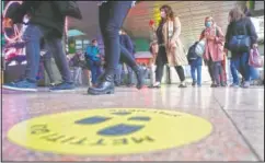  ?? (AP/Antonio Calanni) ?? Commuters wearing face masks to curb the spread of covid-19 walk after getting off a regional train at the Cadorna railway station in Milan, Italy.