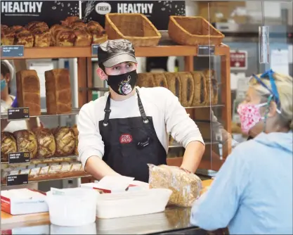  ?? Tyler Sizemore / Hearst Connecticu­t Media ?? Sales manager Jamie Williams helps a customer at the new Cobs Bread in Riverside on Tuesday. The bakery has more than 700 locations in Australia and New Zealand under the name Baker’s Delight.