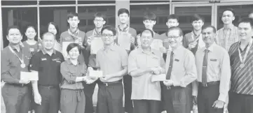  ??  ?? Ting (front, fourth right) and Chin (front, fourth left) hand over the cheque to school principal Wong King Kui (third right) and vice principal Lai Jia Ling (third left) witnessed by teachers and students.