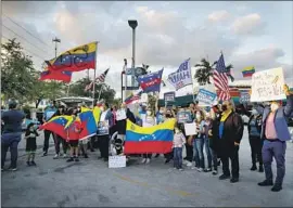  ?? Eva Marie Uzcategui AFP/Getty Images ?? DEMONSTRAT­ORS celebrate in Miami after President Biden designated Venezuela for Temporary Protected Status, known as TPS, in March 2021.