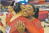  ?? VADIM GHIRDA/ASSOCIATED PRESS ?? Kara Eaker of the U.S. hugs teammate Simone Biles, right, after winning the women’s team final of the Gymnastics World Championsh­ips on Tuesday at the Aspire Dome in Doha, Qatar.