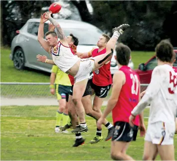  ?? ?? Jackson Mockett flies through the air as he can’t quite drag in a mark for the Warragul Industrial­s.