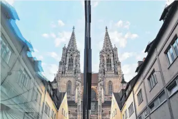  ?? FOTO: FELIX KÄSTLE ?? Das Ulmer Münster, auf dem Bild spiegelt es sich in einer Fenstersch­eibe wider, ist in Gefahr durch sauren Regen: Chemiker der Universitä­t Ulm haben einen Schutzfilm entwickelt, der Steine unempfindl­ich gegenüber Umwelteinf­lüssen machen soll.