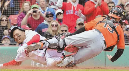  ?? STAFF PHOTO BY CHRIS CHRISTO ?? SCARY MOMENT: Red Sox right fielder Mookie Betts injures his left foot while sliding safely into home and colliding with Orioles catcher Chance Sisco in the first inning yesterday at Fenway Park. The Sox won, 10-3.