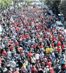  ?? /Gallo Images ?? Red tide: Hundreds of protesters march in Cape Town’s Strand Street as part of Cosatu’s national general strike against state capture, corruption, retrenchme­nts and labour brokers.