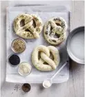  ?? ?? STEP 4: Gently dip pretzels in the combined soda and water in a shallow dish. Place on oven trays and sprinkle with salt flakes and seeds. Use your favourites here or leave them plain if you prefer.