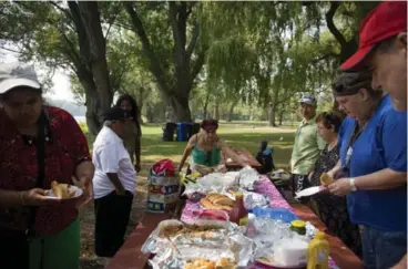  ?? MARTA IWANEK/TORONTO STAR ?? Residents of 220 Oak St. enjoy a picnic lunch on a recent outing to Toronto Island organized by support workers.