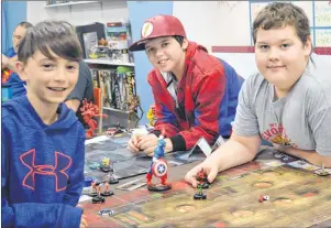  ?? CHRISTIAN ROACH/CAPE BRETON POST ?? From left to right, Nate Bond, Jesse Milley and Avrey Hillier take part in a game of Heroclix at the My Secret Identity Comics and Games” shop in Sydney River on Saturday. The store is the only one selected in the Maritimes to host this year’s Fall...