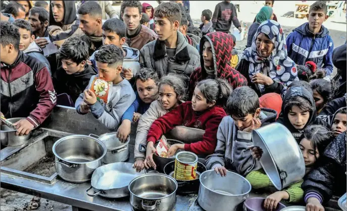  ?? (Foto: Anadoly Agency) ?? Palestinsk­a djeca drže prazne zdjele dok čekaju hranu koju dijele volonteri na punktu humanitarn­e pomoći u Rafahu dok se nastavljaj­u izraelski napadi Gaza, 26. januar 2024.