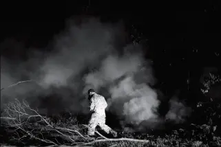  ?? ASSOCIATED PRESS ?? SGT. 1ST CLASS CARL SATTERWAIT­E, OF THE U.S. NATIONAL GUARD, tests air quality near cracks emitting volcanic gases from a lava flow in the Leilani Estates subdivisio­n near Pahoa, Hawaii, on Thursday. Kilauea has destroyed more than 35 structures since...