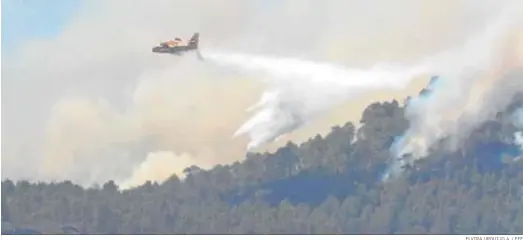  ?? ELVIRA URQUIJO A. / EFE ?? Un avión descarga agua ayer sobre el foco del pinar de Tamadaba, uno de los puntos de donde surgió el incendio de Gran Canaria.