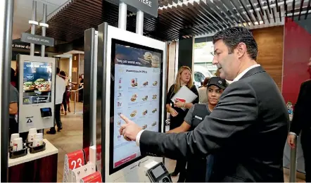  ?? AP ?? McDonald’s chief executive Steve Easterbroo­k demonstrat­es an order kiosk at a New York restaurant.