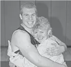  ??  ?? Jason Seaman hugs his mother, Kristi, during his days playing high school basketball in Mahomet, Ill. SUBMITTED