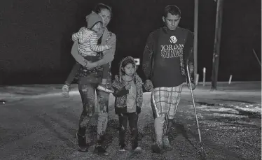  ?? Gregory Bull / AP ?? Pedro Mercado, un salvadoreñ­o de 27 años, camina con su esposa y dos hijas de tres y cuatro años hacia un centro de procesamie­nto de migrantes que piden asilo en Estados Unidos en La Joya, Texas, el 12 de mayo. Dijo que usa una muleta porque fue herido en una pierna por un individuo que lo atacó con un machete.