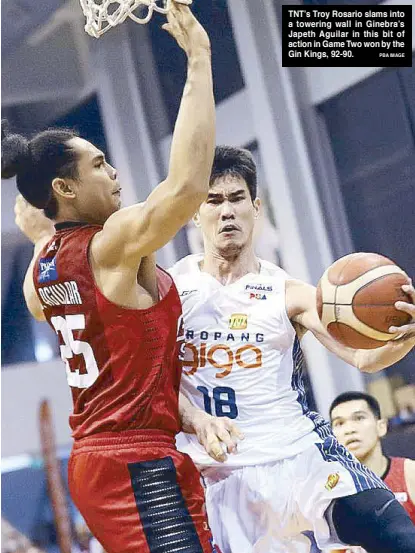  ?? PBA IMAGE ?? TNT’s Troy Rosario slams into a towering wall in Ginebra’s Japeth Aguilar in this bit of action in Game Two won by the Gin Kings, 92-90.