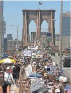  ?? KEVIN HAGEN/AP ?? Activists carry signs across the Brooklyn Bridge during a rally to protest the Trump administra­tion’s immigratio­n policies Saturday in New York.