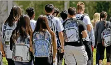  ?? SOUTH FLORIDA SUN-SENTINEL ?? Beginning Jan. 8, Butler High School will require students to leave backpacks or book bags in their lockers during the school day. Many districts are evaluating security measures and coming up with their own rules. Above, students wear clear backpacks outside of Marjory Stoneman Douglas High School in Parkland, Fla.