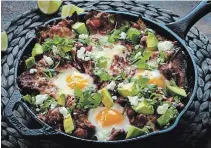  ?? E. JASON WAMBSGANS PHOTOS CHICAGO TRIBUNE ?? Eggs bake directly in the tortilla chip and tomato sauce mixture. After coming from the oven, the chilaquile­s is garnished with avocado, feta and cilantro