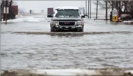  ?? Herald photo by Ian Martens ?? A resident drives slowly along a flooded section of roadway Monday at Wilson Siding south of Lethbridge along Highway 4. Lethbridge County lifted the state of local emergency Tuesday afternoon. @IMartensHe­rald