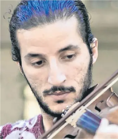  ??  ?? Ameen Mokdad played his violin in the innermost room of his home in Mosul with blankets on the windows to muffle the sound.