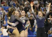  ?? KEITH BIRMINGHAM — STAFF PHOTOGRAPH­ER ?? UCLA teammates celebrate with Margzetta Frazier after she scored a 9.975 in the floor exercise Saturday.