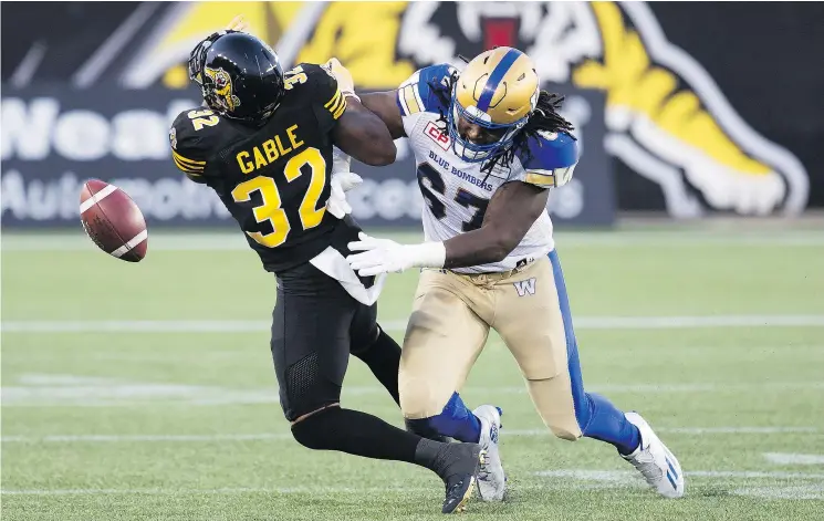  ?? — THE CANADIAN PRESS FILES ?? C.J. Gable, left, and the Hamilton Tiger-Cats received another punishing blow Saturday, losing to Cory Johnson and the Winnipeg Blue Bombers 39-12.