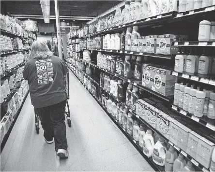  ?? MANDI WRIGHT/ USA TODAY NETWORK ?? Diane Strauss, 55, of Warren fills online grocery orders at Holiday Market in Royal Oak, Mich., in March. Online grocery orders at the store have seen an uptick since the coronaviru­s outbreak.