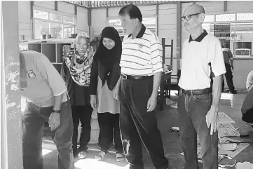  ??  ?? (From third left) Fauziah, Ting and Othman look at painting works in one of the classrooms.