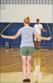  ??  ?? Two adults jump rope during a wellness session at a seminar in Pottstown for educators. Jumping rope isn’t just a childhood game but is also great exercise for adults as well. Lower body strength: To target the lower body, jump on one foot at a time....