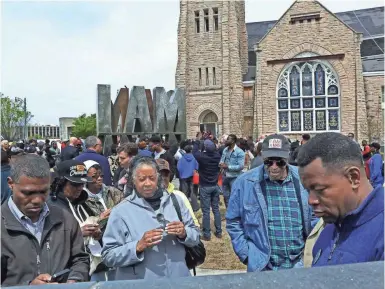  ??  ?? Wearing his “I Am A Man” cap, former sanitation worker Ozell Ueal looks for his engraved name during the I Am A Man Plaza unveiling near Clayborn Temple on Thursday. YALONDA M. JAMES/THE COMMERCIAL APPEAL