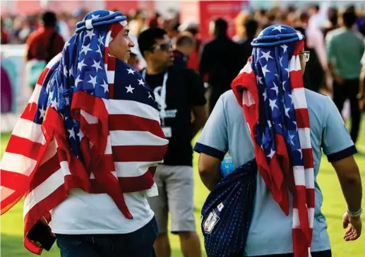  ?? AP PHOTO ?? Dos aficionado­s de Estados Unidos pasean por Doha con sus banderas a modo de kufiya en la cabeza.