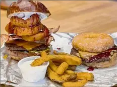  ?? Susie Davidson Powell / For the Times Union ?? Impossible pattie options at Wizard Burger include topped with onion rings and fried pickles and on a glazed doughnut.