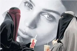  ??  ?? Ayah (left), 37, and Aisha, 18, members of the group Kvinder I Dialog (Women In Dialogue), sit in a shopping centre near Copenhagen.