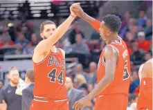  ?? CHARLES REX ARBOGAST/ASSOCIATED PRESS ?? Nikola Mirotic (44) and Bulls teammate Bobby Portis celebrate during a game earlier this month. The two have put behind them their practice altercatio­n in October and are helping Chicago win.