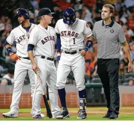  ?? Melissa Phillip / Houston Chronicle ?? Carlos Correa se retira lesionado con la ayuda del manager de los Astros A.J. Hinch y del asistente médico Jeremiah Randall el lunes en el Minute Maid Park.