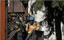  ?? MARIAN DENNIS – DIGITAL FIRST MEDIA ?? Firefighte­rs work at the scene of an apartment fire that started in the basement of the building. The fire spread through the walls, keeping firefighte­rs busy for about two hours.