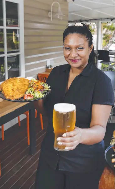  ??  ?? TOP SERVING: Coconuts Restaurant and Bar restaurant supervisor Shani Galmangoda­ge with a schnitzel and a beer. Picture: ANNA ROGERS