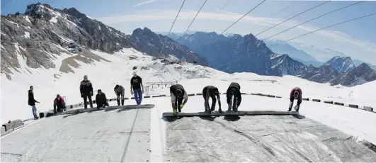  ?? MATTHIAS SCHRADER/ THE ASSOCIATED PRESS FILES ?? Workers cover a glacier in southern Germany with plastic in 2011 to keep the glacier from melting during the summer months.