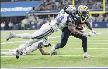 ?? Photos by Ron Jenkins / Associated Press ?? New Orleans’ Alvin Kamara is hit by Dallas’ Jaylon Smith and stopped short of the goal line in the first half Thursday. The Saints were shut out in the first half for the first time since 2014.