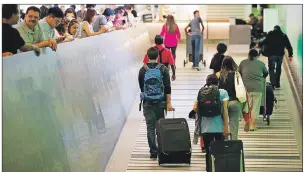  ?? AP PHOTO ?? Travellers make their way up the arrival ramp at the Tom Bradley Internatio­nal Terminal at the Los Angeles Internatio­nal Airport Thursday.