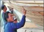  ?? WEI PEIQUAN / XINHUA ?? Shipbuilde­rs apply traditiona­l skills to craft a wooden boat in Zhangwan, Fujian province.