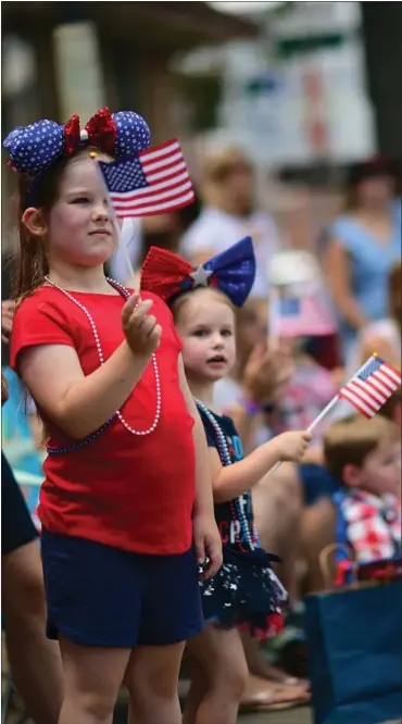  ?? MARK MAKELA / GETTY IMAGES ?? Children wave U.S. flags at a 4th of July parade last year in Pottstown, Pa. As this year’s holiday nears, there’s no shortage of issues factoring into national angst.