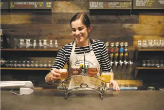  ??  ?? From top: Bartender Jarred Robson talks with Andrew Mesetz at Secret Trail Brewing Co. in Chico. Haley Meace serves up a sampler at Secret Trail Brewing. The brewery is one of several to sprout up in this town known as home to Sierra Nevada Brewing. A...