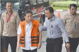  ??  ?? INDONESIAN parliament speaker, Setya Novanto (in orange vest), walks as he arrives at the Corruption Eradicatio­n Commission (KPK) building in Jakarta, Indonesia in this Nov. 21 photo taken by Antara Foto.